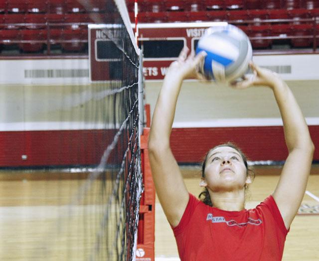 Kelly Burns, freshman setter, sets for her teammates after practice Tuesday in Reynolds Coliseum. Burns played volleyball and basketball at Jackson Hole High School in Wyoming and is majoring in business management. Photo by Tim O'Brien