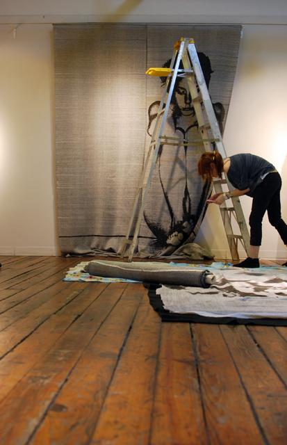 Nealy Andrews sets up "Holding In," a woven print by Andrea Donnelly, an N.C. State graduate from the College of Design. Donnelly's woven work is currently exhibited in Artspace, a gallery in downtown Raleigh. Photo by Sarah Tudor