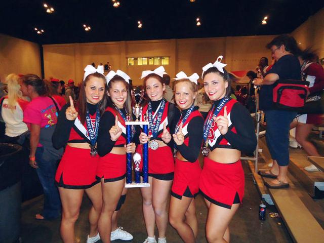 The Ladies of the Pack all-girl cheerleading stunt team poses with their trophy and medals after winning first place in the Canam College National competition last weekend. The five-person team defeated two other teams, one of which was the three-time defending champion.