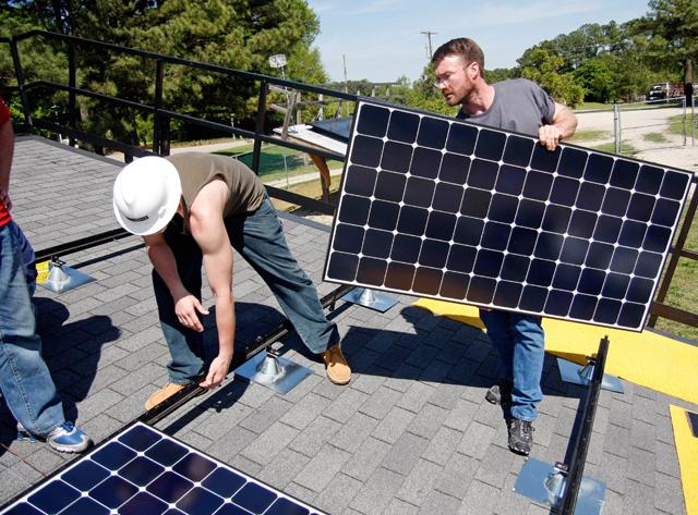 Working at the University Solar Center, Pennsylvanian engineers Matt Wilson, from Secco Inc., and Jeff Sloat, from Summit Electric, instal solar panels as part of a national training course put on by SunPower Corporation Thursday. Wilson had worked in the solar installation industry and installed about 100 systems. Sloat is training to be the lead technician at his company. Photo by Tim O'Brien.