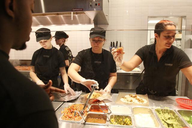 Workers assemble burritos at the newest Chipotle Mexican Grill location on Hillsborough Street, right by campus. Photo by Alex Sanchez.