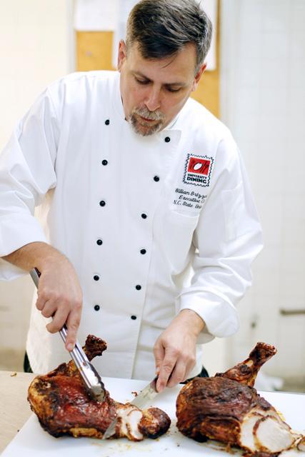 Executive Chief of NC State University, Bill Brizzolara works in the kitchen on the fourth floor of Tally, preparing two turkeys with herb seasoning for a catered event. Photo by Oliver Sholder