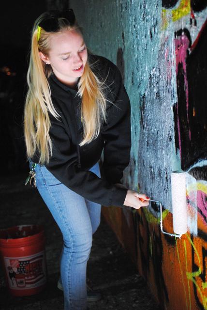 Erin Lehnert, a freshman in business, paints the Free Expression Tunnel white during the Ram Roast Thursday night. The entire tunnel was painted red and white in support of the Wolfpack as they prepare to take on UNC on Saturday. Thursday, Nov. 3, 2011. Photo by Michael Pratt.