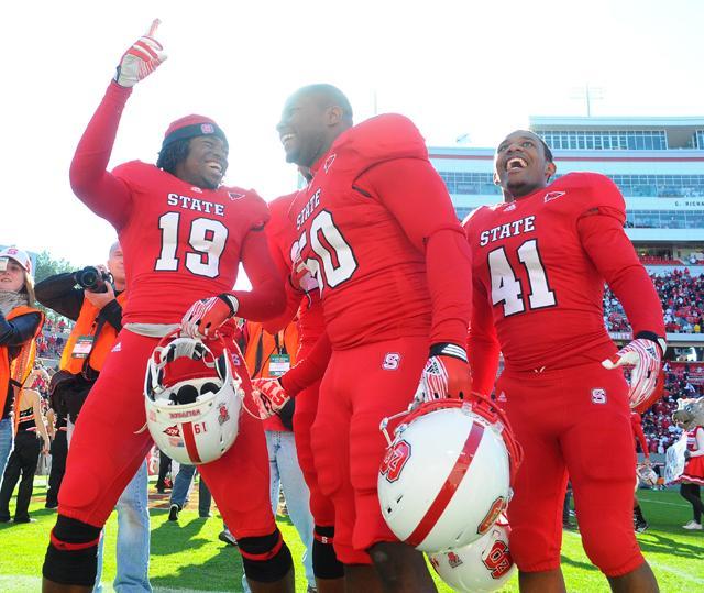 Freshman wide receiver Maurice Morgan (19), senior linebacker Calvin Forbes (50) and sophomore defensive back Milton Hall celebrate the Wolfpack's 13-0 victory over UNC at Carter-Finley Stadium Saturday, Nov. 5. Photo by Brent Kitchen.