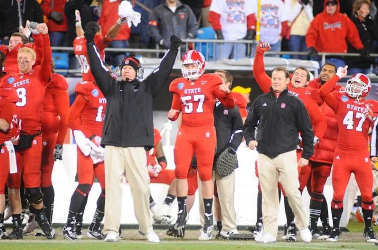 Coach Tom O'Brien throws his arms up in celebration at the end of the Belk Bowl at Bank or America Stadium in Charlotte Tuesday Dec. 27. The Pack defeated Louisville 31-24. Photo by Brent Kitchen.