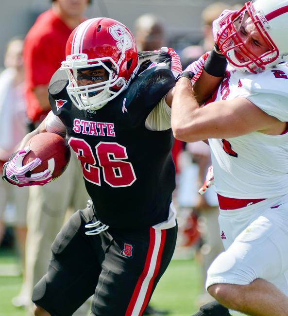 Redshirt sophomore halfback Tony Creecy pushes off sophomore defensive back Josh Stanley during the Kay Yow Spring Football game Saturday, April 21. Creecy led both teams in rushing yardage with 45 in 16 carries. In the black team's 32-7 win over the white team. Photo by Alex Sanchez.