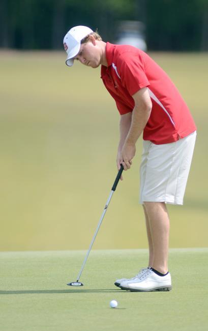 On the green of the third hole of Lonnie Poole Golf Course on Centennial Campus, senior Mark McMillen putts his ball into the hole for par Sunday, April 15. McMillen finished the annual Wolfpack Spring Open tied for 7th with a score of +1. Photo by Ryan Parry.