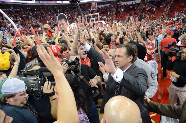 N.C. State head coach Mark Gottfried high fives fans who rushed the court after defeating No. 1 Duke 84-76 in PNC Arena Saturday, Jan. 12, 2013.