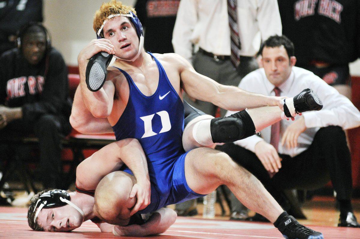 Head coach Pat Popolizio watches as freshman Tyler Hunt is held against the mat against Duke Wednesday, Feb. 20, 2013. Hunt wrestled in the 141 weight class in the Wolfpack's 22-9 loss to the Blue Devils at Reynolds Coliseum. Photo by Ryan Parry.