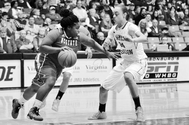 Junior guard Myisha Goodwin-Coleman drives against James Madison University guard Jazmon Gwathmey in the second round of the Women's National Invitational Tournament March 24, 2013. The Wolfpack dropped the game to the Dukes 66-72. Photo contributed by Sean Cassidy/The Breeze.