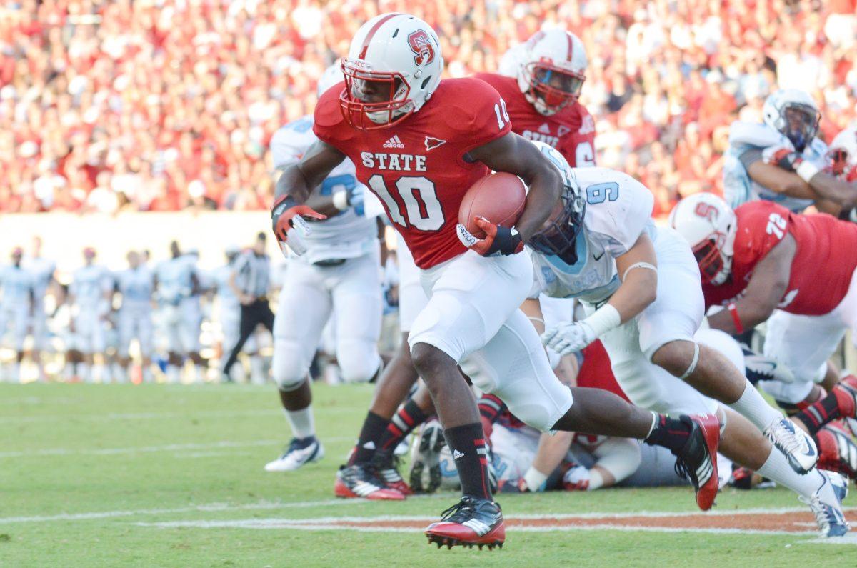 Freshman running back Shadrach Thornton runs the ball around around the Citadel defense during the ACC Military Appreciation Day football game in Carter-Finley Stadium Saturday, Sept. 22, 2012. Thornton, playing in his first collegiate football game, carried for 145 yards and two touchdowns, helping to lead the Wolfpack to a 52-14 victory over the Bulldogs. Photo by John Joyner.