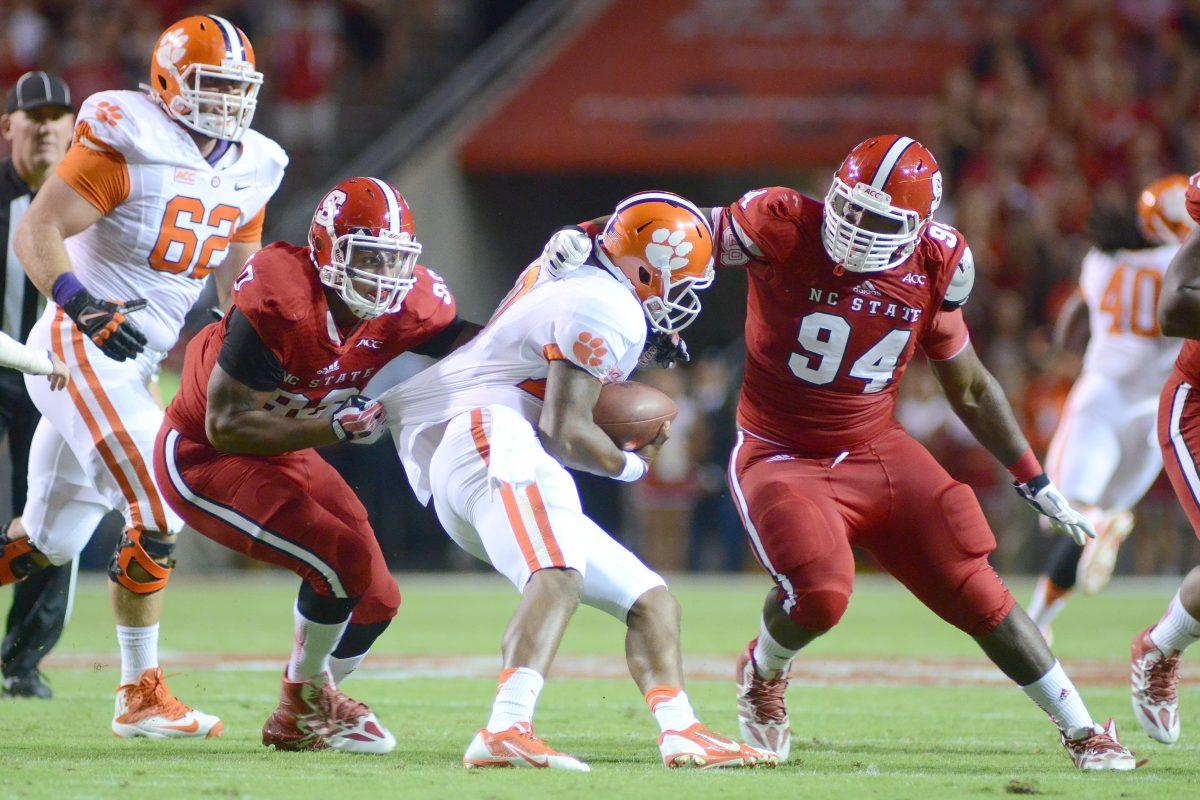 Redshirt sophomore defensive end Mike Rose and freshman defensive tackle Monty Nelson sack Clemson's quarterback Thursday, September 19, 2013. The Tigers led the Wolfpack 13-7 at the half at Carter-Finley Stadium. Photo by Ryan Parry.