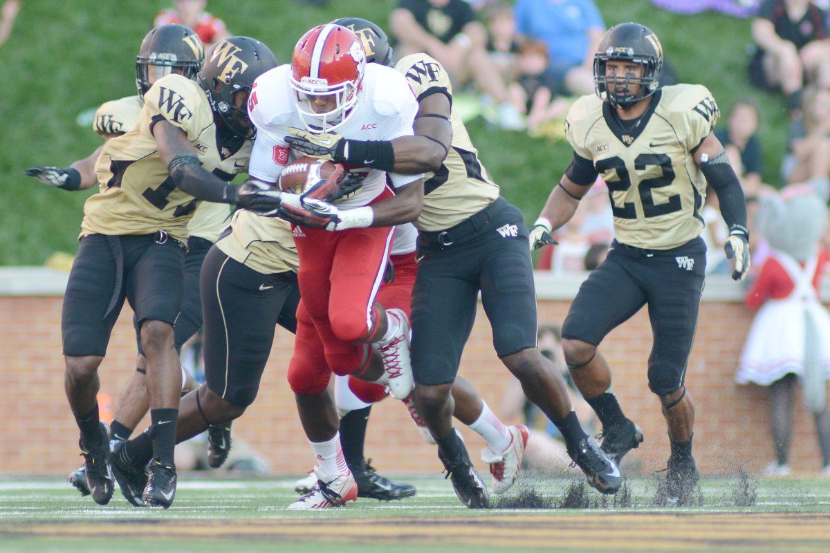 Freshman wide receiver Johnathan Alston is tackled Sat. Oct. 6, 2013 at BB&amp;T Field against Wake Forest. The Demon Deacons defeated the Wolfpack 28-13. Photo by Chris Rupert.