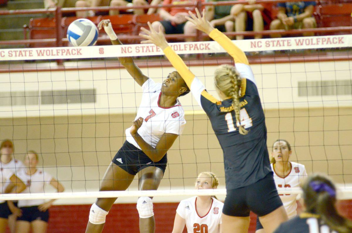 Senior middle blocker Brie Merriwether spikes the ball over the net Friday, Sept. 6, 2013. The Wolfpack defeated Applachian State 3-0 at Raynold's Coliseum.