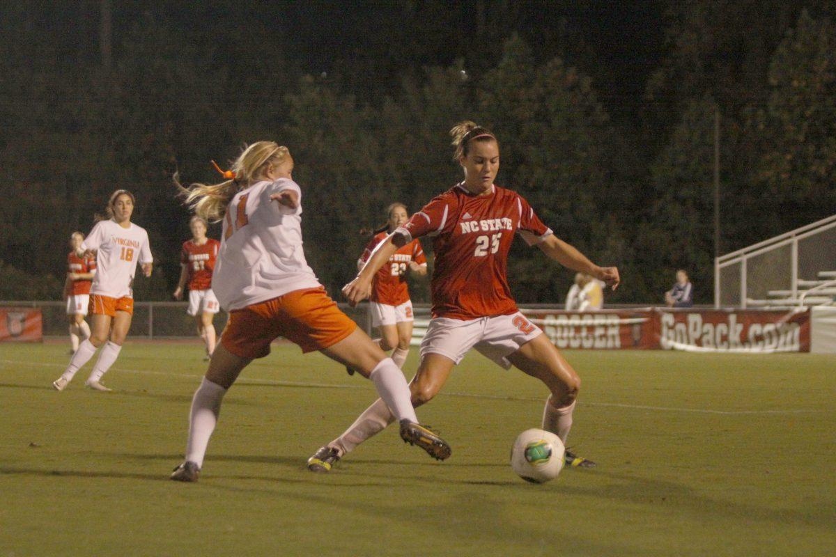 Sophomore forward Caroline Gentry gains possession of the ball from Virginia Cavalier's sophomore Brittany Ratcliffe at Dale Field, on Thursday, Oct. 17, 2013. Photo by Victoria Crocker.
