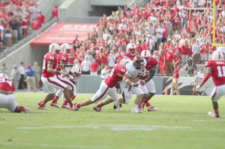 N.C. State freshman linebacker Drew Davis, junior defensive end Art Norman, and junior defensive tackle T. Y. McGill tackle Central Michigan running back Saylor Lavallii during NCSU's 45-14 victory at Carter-Finley Stadium on Saturday, Sept. 28, 2013.