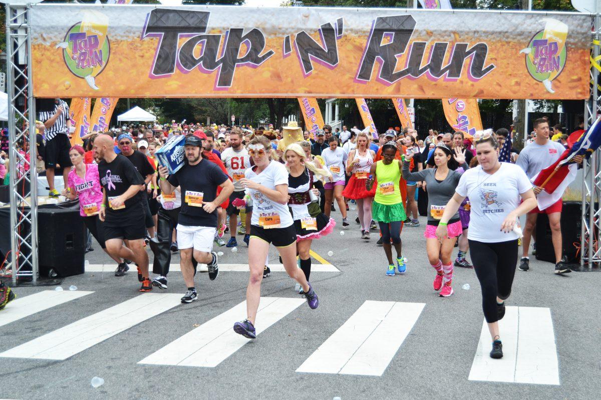 Participants of the Tap 'N' Run 4K start running after chugging their first beer at the beginning of the race on Hillsborough Street on Saturday, Oct. 19, 2013. Photographed by Victoria Crocker.