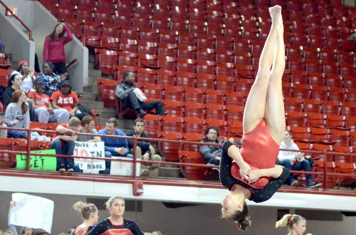 Senior Stephanie Ouellette holds pose through a flip while on floor during N.C. State gymnastics meet against West Virginia on Jan. 23. Ouellette scored a 9.725 on floor in the Wolfpack's close win with a score of 195.200-195.150 at Reynolds Coliseum.