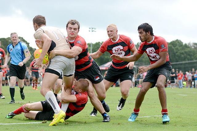 Seniors Alex Davis and Adam Hockaday tackle a Wake Forest player as teammates Stephen Glass and Neel Kuila prepare to give support Saturday afternoon, Sept. 13 at Method Rd. Field. The Wolfpack brought home their first win of the season over the Demon Deacons 31-15. Photo by Caide Wooten.