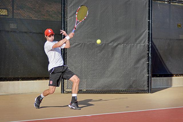 Junior Robbie Mudge powers a forehand to the opposite court during his singles match with Boston College's Jonathan Raude at the J.W. Isenhour Tennis Complex Friday April 4, 2014. The Wolfpack defeated the Eagles, dropping only one singles match. Technician Archive.