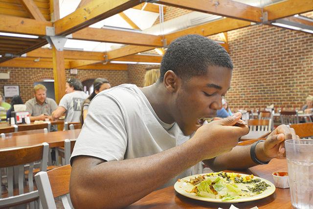 Freshman in computer engineering Dante Buckley enjoys some spinach with melted cheese and salad greens at Fountain Dining Hall Tuesday.&#160; Buckley said that the spinach tastes really good and especially liked the cheese with it. University Dining held a focus on kale and collards during lunchtime at the dining halls and the cheese proved to be a great way for students to eat their greens.