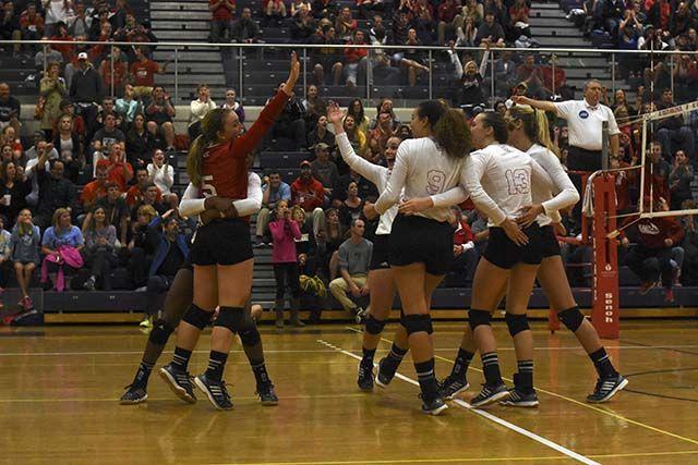 Junior libero Rachel Eppley jumps into the arms of sophomore outside hitter Perry Ramsey as the Wolfpack volleyball team celebrates winning a tremendous point against Wake Forest on October 2nd at Broughton High School. The Wolfpack took down Wake Forest 3-1 with a team total of 60 kills, 57 digs, and 14 blocks.