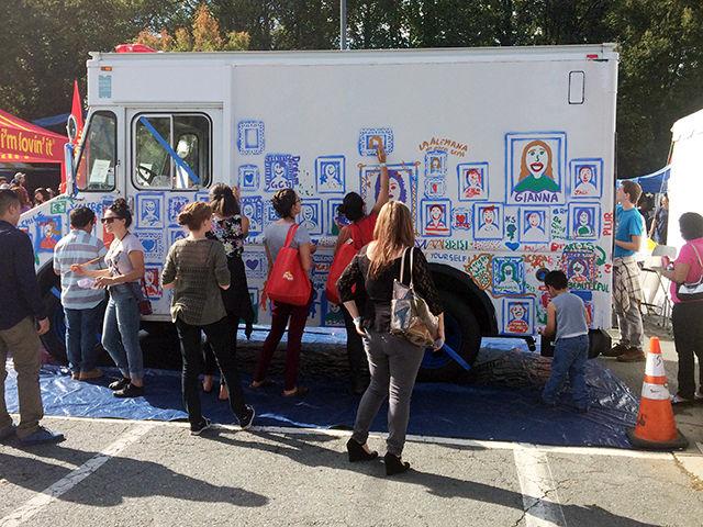 Participantes pintan retratos en la pared de una camioneta en el Festival Latinoamericano de Charlotte. Era para epitomizar los varios rastros que representan la identidad latina.&#160;