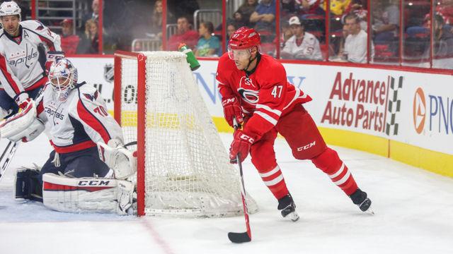 Defenseman Michal Jordan swings around the back of the goal to make an attempt to score against the Captials in the preseason game on September 30th in PNC Arena. The Hurricanes ended the game with a hard fought win 4-3 in a shootout.
