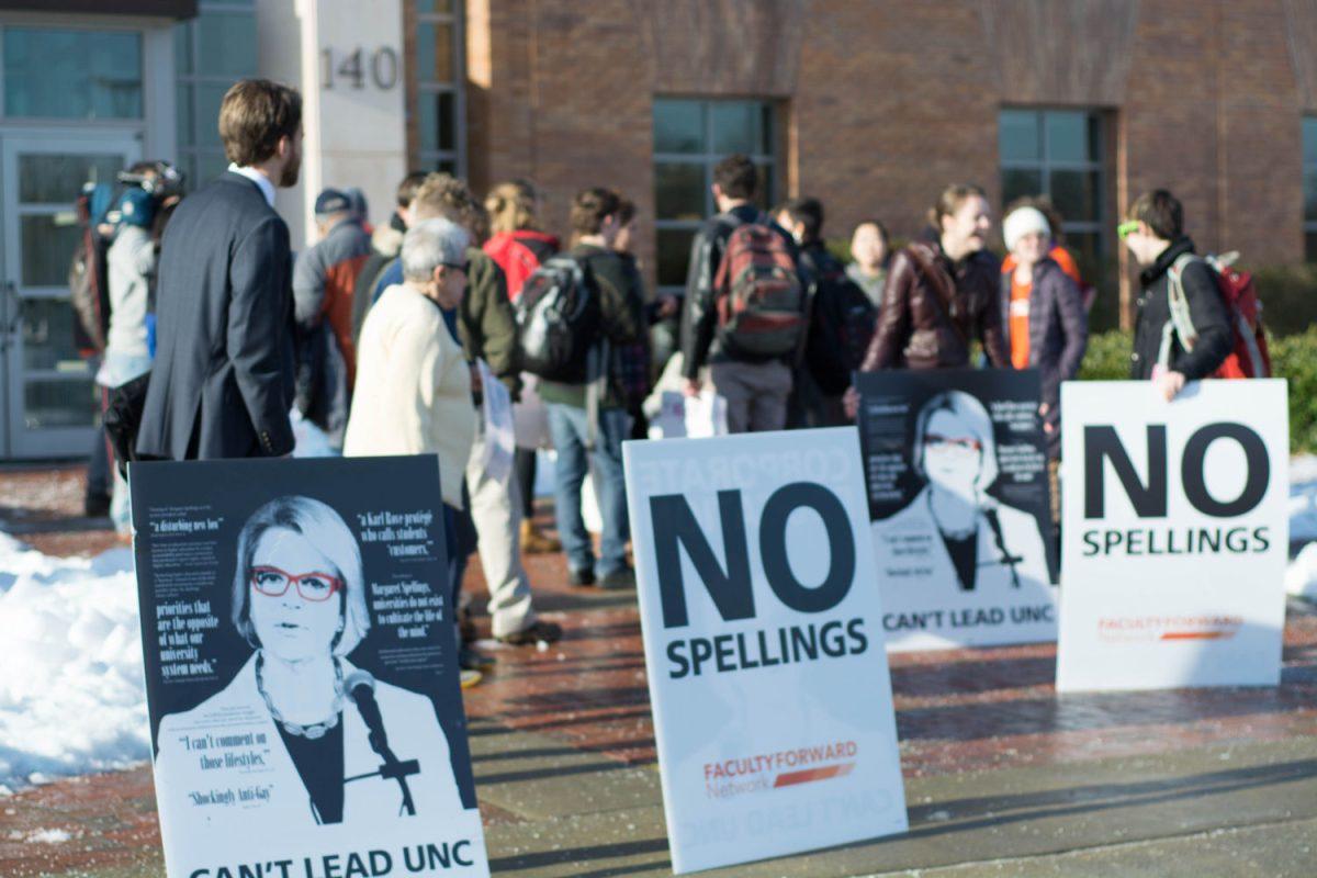Signs posted outside of the Board of Governors meeting on Tuesday in Chapel Hill.