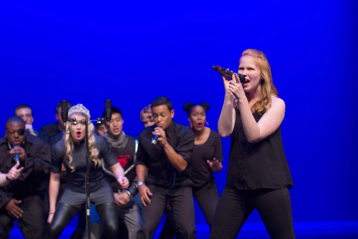 Anna Griffin, a senior studying religious studies, sings a solo while the rest of the group breaks it down during Accapology's Spring Concert at Stewart Theater on March 30, 2016. The concert, called "Writing is Hard: Stories through Song", told the story of a struggling freshman english major trying to finish an assignment as told through twelve acapella performances.