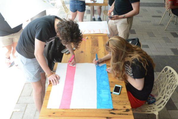 Travis Herrington, a sophomore majoring in english, and Chloe Holland, a sophomore majoring in animal science, color the trans flag to protest Margaret Spellings's visit to NC State's campus on Wednesday, April 20th. Protesters gathered on Stafford Commons and then in the lobby of Talley Student Union to show their opposition to Spellings taking the position of president of the UNC public university system.