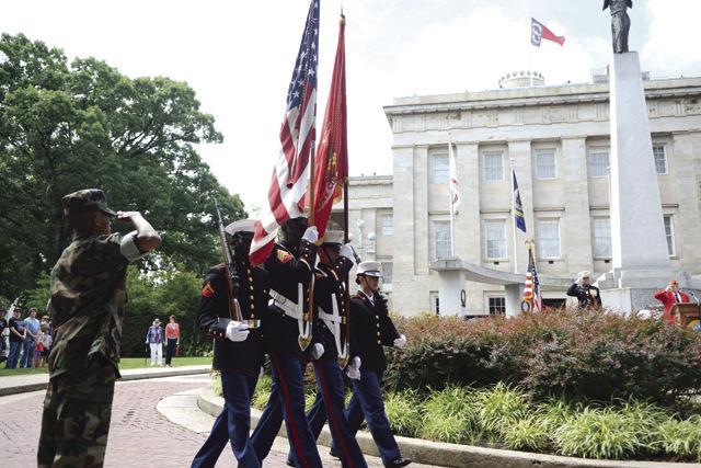 A Capitol City Young Marine salutes as the US Marine Corps Color Guard presents the colors during Raleigh's Memorial Day wreath-laying ceremony held Monday morning at the Capitol Building.