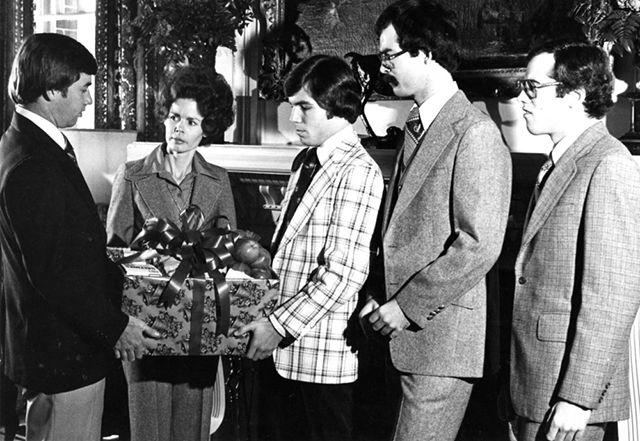Circa 1970: Carolyn Hunt, wive of Gov. James Hunt, poses with fraternity members at a food drive.