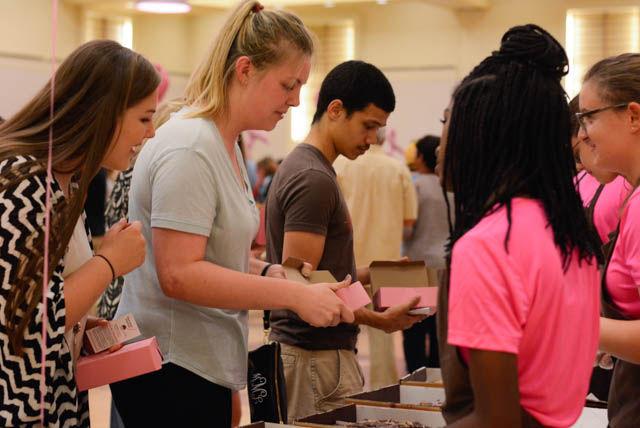 Meagan McNairy, a freshman studying marketing, receives a slice of chocolate cake from Derrice Haynes, a junior studying biology and volunteer of the Chocolate Festival. McNairy's sister Meredith, a student at UNC-Chapel Hill, looks on at the other flavors of cake. Proceeds from the Chocolate Festival go to the Kay Yow Cancer Foundation.