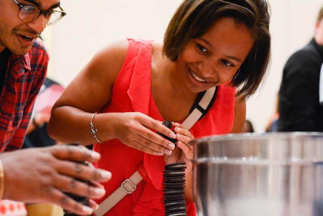 Doriane Taylor, a senior studying chemistry, looks at her competitor's Oreo stack in the State Ballroom at Talley Student Union on Sept. 30. For the competition, two participants had 20 seconds to stack as many Oreos as possible without them falling over. The competition was part of the Chocolate Festival, an event at which the proceeds go to the Kay Yow Cancer Foundation.
