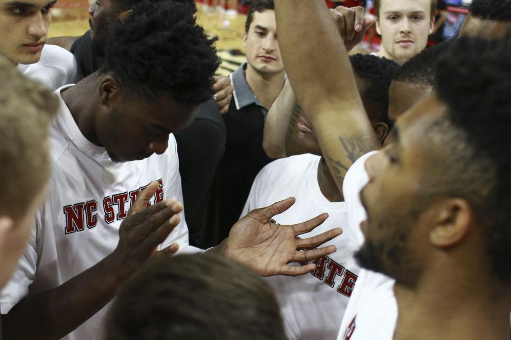 The team huddles up after warming up before their game against Boston University on Dec. 3, 2016. The Wolfpack held off the Terriers to win 77-73 at PNC Arena.