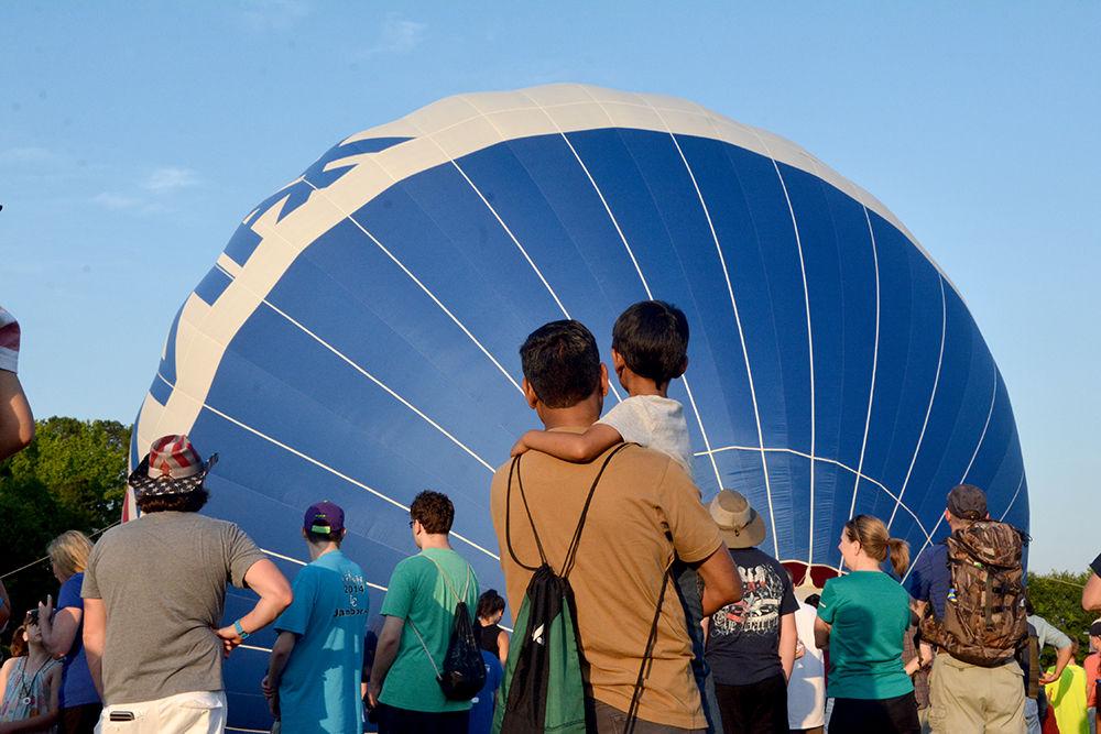 Sanjeev Gharmode holds his son, Prayan, while they admire the set up of more than two dozen hot air balloons at the WRAL Freedom Balloon Festival on May 27, 2017 in Fuquay-Varina. The event featured about 30 hot air balloons, food and beer vendors and live music performances.
