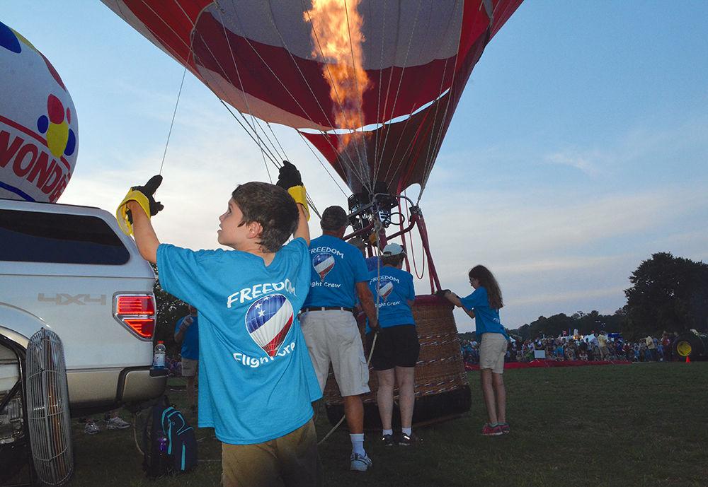 Luke Andrew, 7, helps other volunteers set up a hot air balloon at the WRAL Freedom Festival on May 27, 2017 in Fuquay-Varina. Andrew said this was one of "the coolest nights ever." The event featured more than 30 hot air balloons, food and beer vendors and live performances.