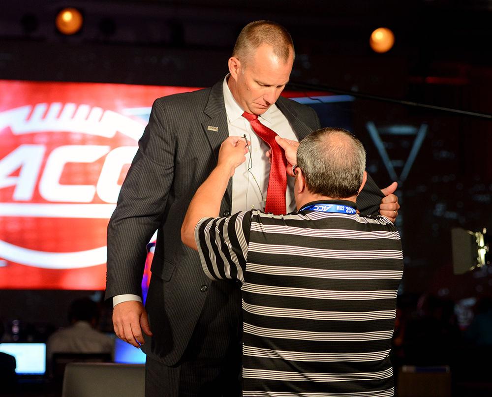A tech assistant removes the microphone from head coach Dave Doeren following his ESPN interview on Thursday, July 13 in Charlotte, North Carolina. Doeren has high hopes for this year's football season.