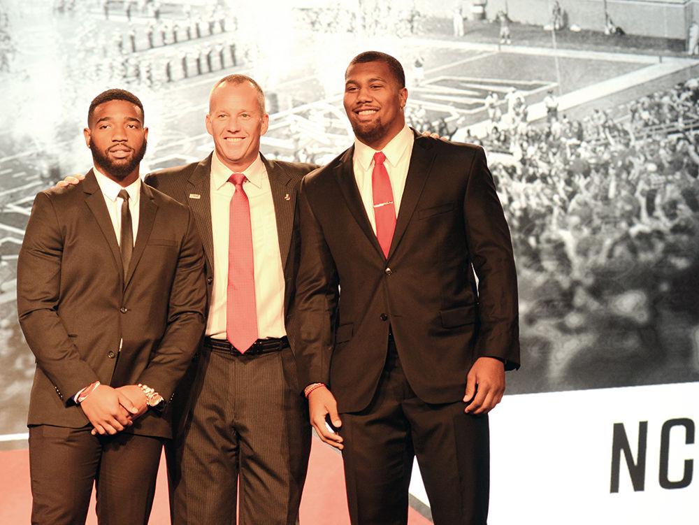Senior Jaylen Samuels, Coach Dave Doeren and Senior Bradley Chubbs huddle for a group photo at the 2017 ACC Kickoff on Thursday, July 13 in Charlotte, North Carolina. Samuels and Chubbs were chosen to represent NC State's football program at this year's ACC Kickoff.