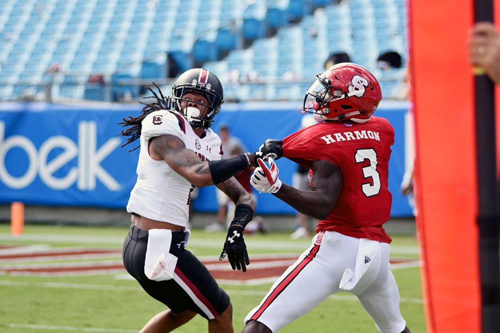 A University of South Carolina football player tugs on sophomore wide receiver Kelvin Harmon in the Bank of America Stadium in Charlotte on Saturday, Sept. 2. Harmon had 10 hits for 114 yards. The Wolfpack fell to the Gamecocks 35-28.