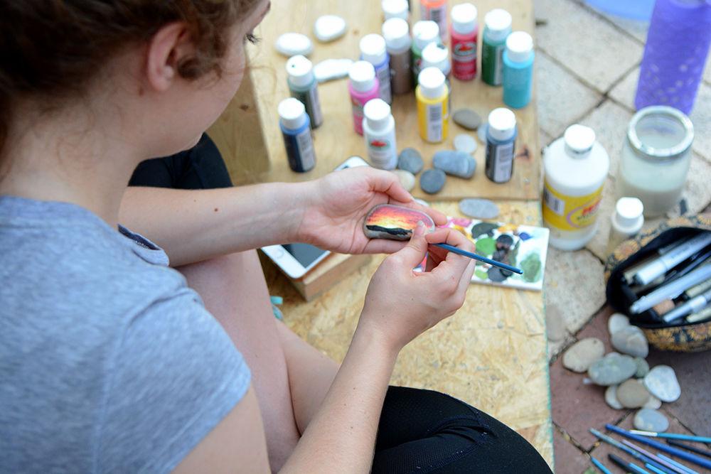 Katie Brooks, a second-year studying art and design and current Caldwell Fellow, paints a landscape on small stones Wednesday to be sold at the Caldwell Fellows shack during Shack-A-Thon. In addition to Brooks' miniature paintings, the Caldwell Fellows shack sold plants, second-hand clothing, pressed fern art pieces and baked goods to raise money for Habitat for Humanity.