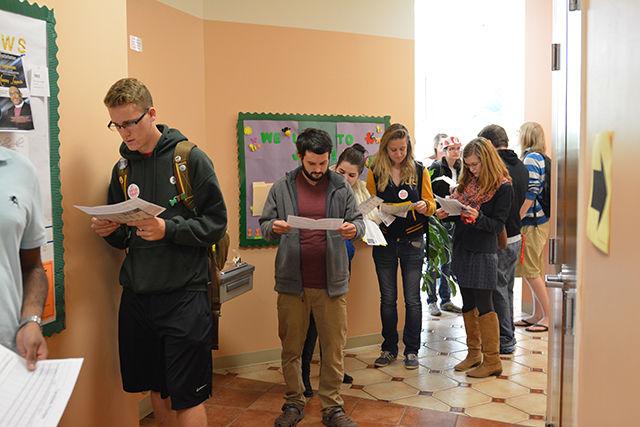 The line to vote extends outside the doors at the Freedom Temple Church polling location on Nov. 4, 2014. Students reviewed final campaign materials about candidates that were handed out outside the doors.