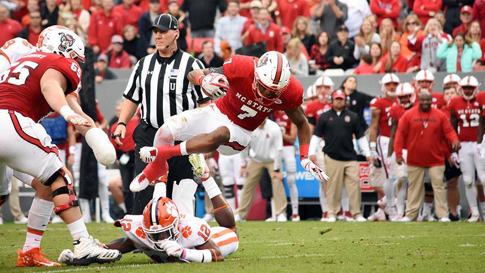 Junior running back Nyheim Hines leaps over a Clemson defender during the Homecoming game in Carter-Finley Stadium, Saturday, Nov. 4. Hines had a net gain of 34 yards during the game. The Wolfpack lost the Homecoming game against Clemson, 31-38.