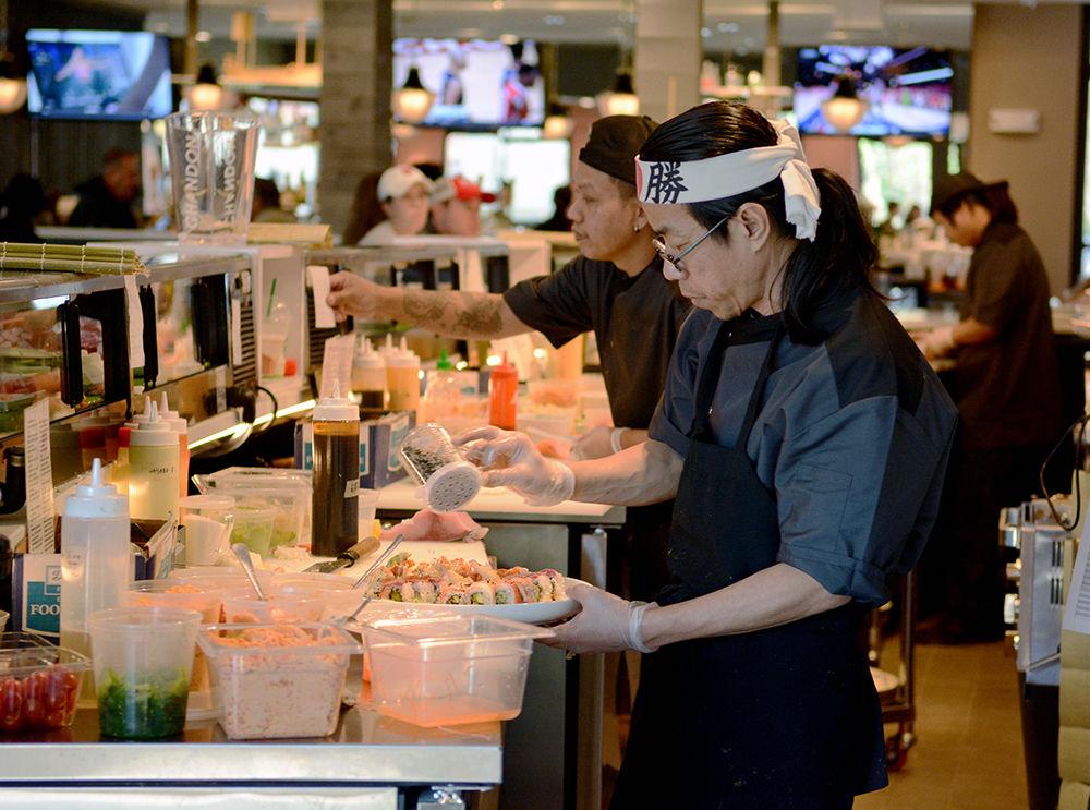 Head Chef Sakorn Buyam, also known as Pat, prepares a plate of sushi behind the sushi bar at recently reopened restaurant Sushi Nine on Saturday. Located off of Western Blvd., Sushi Nine is once again receiving customers in a new building after the original building burned down in 2016.