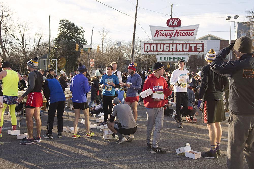 Challengers and causal runners pile into the midway point at Krispy Kreme to eat their dozen doughnuts as part of the annual Krispy Kreme Challenge, Saturday, Feb. 3. This is the fourteenth year that casual runners and challengers ran five miles from the Memorial Belltowerto the Krispy Kreme on Person Street, and back to the Memorial Belltower in one hour to raise money for the UNC Children's Hospital in Chapel Hill.