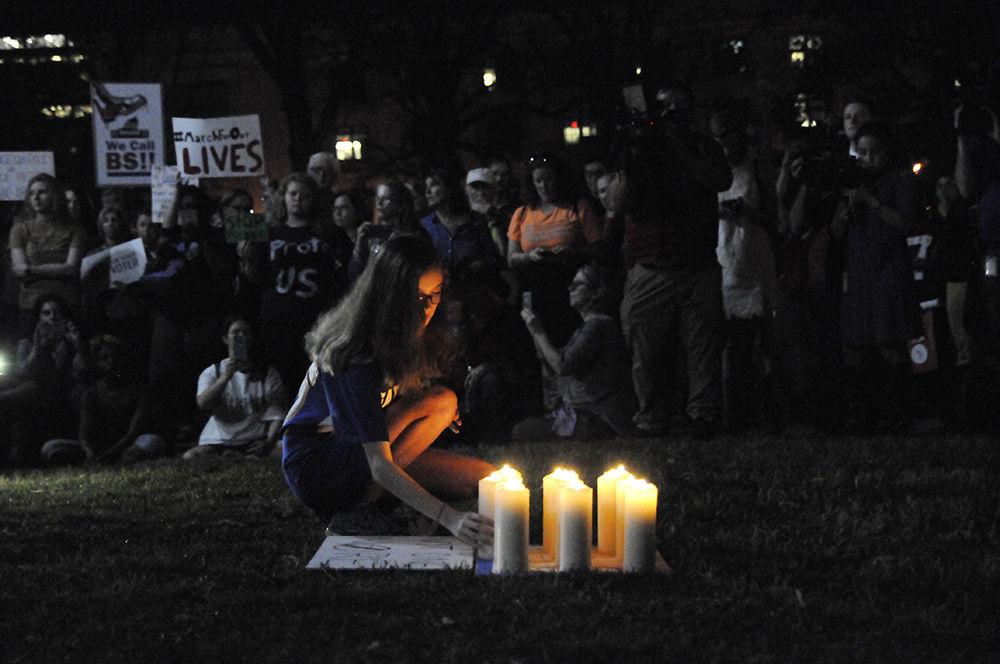 Piper Broad from Garner High School sets down a candle onto the lawn of the capitol building in downtown Raleigh during a ceremony hosted during the Students March on the Capitol on Tuesday. The candles represent each of the lives taken in the recent school shooting in Parkland Florida. The protest called for regulation of gun ownership and preventative measures such that a tragedy of this kind never happens again.