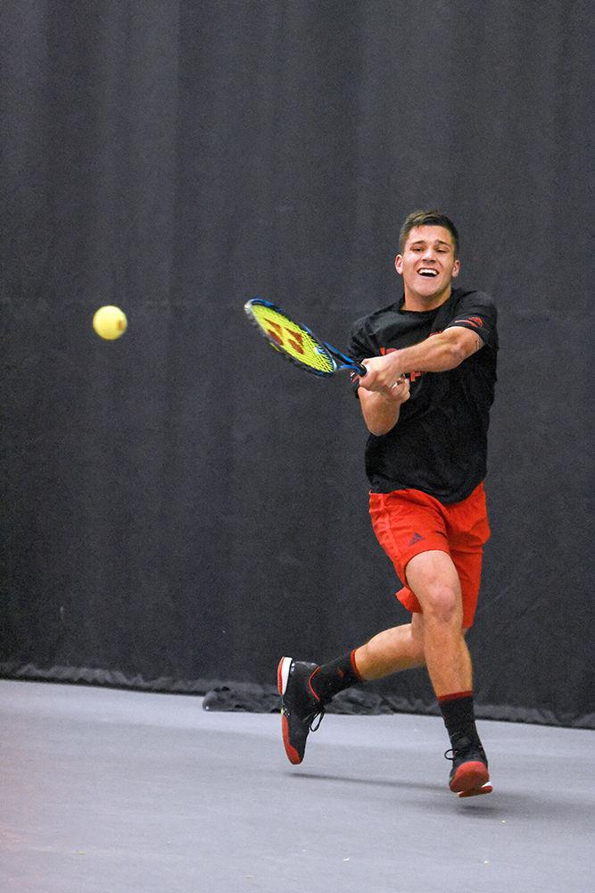 Sophomore Alexis Galarneau hits a powerful backhand against the Texas Longhorns on Friday, March 2 in the J.W. Isenhour Tennis Center. Galarneau lost his singles match 2-6, 7-5, 6-4 against his opponent. The Wolfpack lost 4-1 overall to the Longhorns making this their first loss of the season.