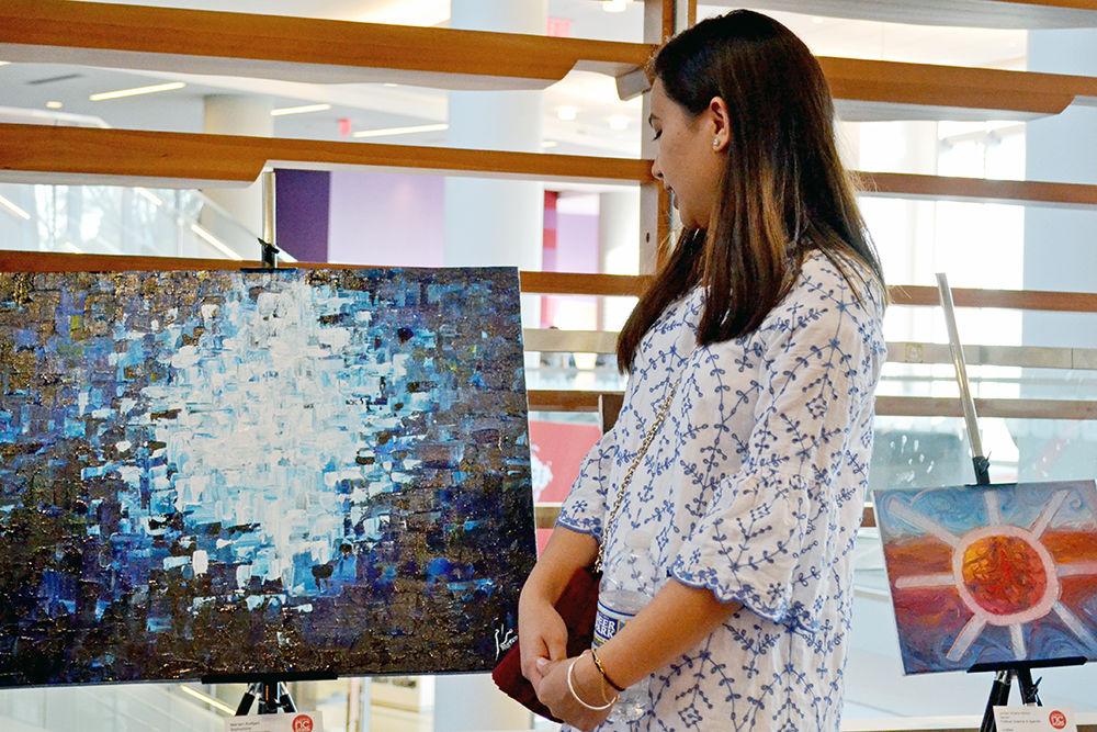 Marram Andijani, a second-year studying chemical engineering, looks at her piece, Deep Blue, during the Student Art Sale in Talley Student Union on Friday. The piece, composed of acrylic paint on canvas, was inspired by the reflection of the sun on the ocean and was sold for $280.