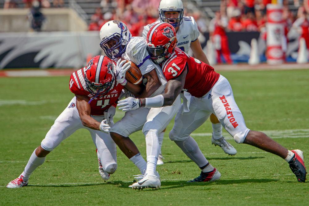 Junior cornerback Nick McCloud and redshirt junior safety Jarius Morehead pin a James Madison University player on Saturday, Sept. 1 at Carter Finley Stadium. The Wolfpack beat JMU 24-13.